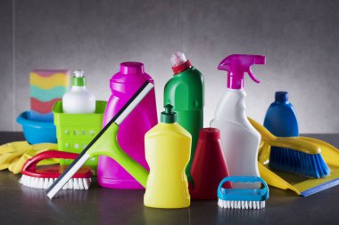 Ev temizlik ürünleri gri ıslak zeminde renkli kümesi. Tipografi için yer.