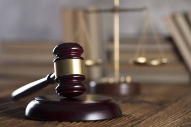 Yargıç rustik ahşap masa üzerinde tokmak. Kitaplık arka plan.