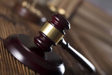 Yargıç rustik ahşap masa üzerinde tokmak. Kitaplık arka plan.