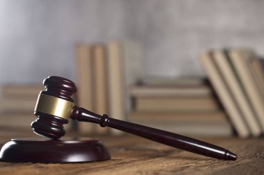 Yargıç rustik ahşap masa üzerinde tokmak. Kitaplık arka plan.