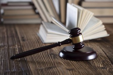 Yargıç rustik ahşap masa üzerinde tokmak. Kitaplık arka plan.