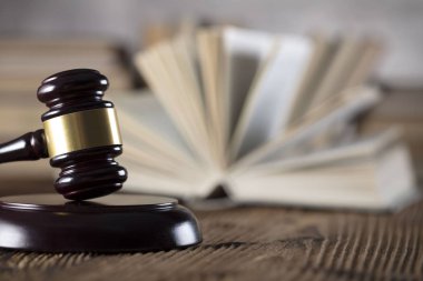 Yargıç rustik ahşap masa üzerinde tokmak. Kitaplık arka plan.