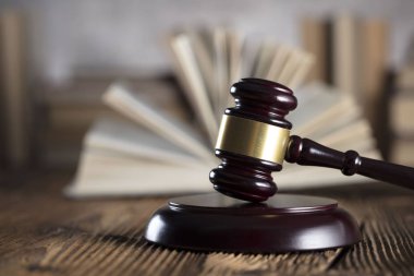 Yargıç rustik ahşap masa üzerinde tokmak. Kitaplık arka plan.