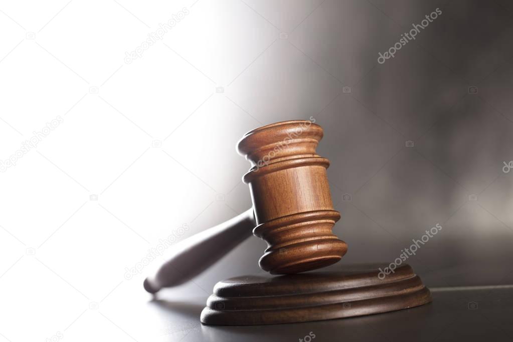 Judge antique gavel - law and justice symbol on stone table and background.