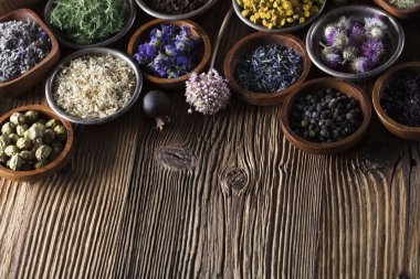 Alternatif Tıp. Ahşap rustik masa üzerinde kaseler, harç ve tıp şişelerde otlar.