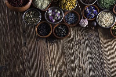 Alternatif Tıp. Ahşap rustik masa üzerinde kaseler, harç ve tıp şişelerde otlar.