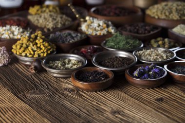 Alternatif Tıp. Ahşap rustik masa üzerinde kaseler, harç ve tıp şişelerde otlar.