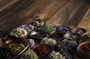 Alternatif Tıp. Ahşap rustik masa üzerinde kaseler, harç ve tıp şişelerde otlar.