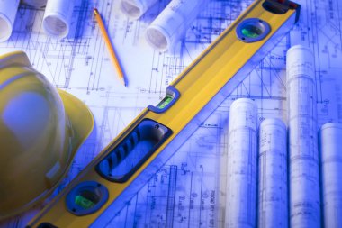 Mimarlık ve inşaat kavramı. Rulo planları, libela ve kask oluşturucu. 