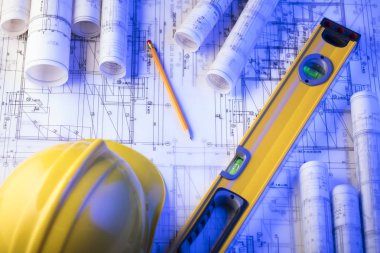 Mimarlık ve inşaat kavramı. Rulo planları, libela ve kask oluşturucu. 