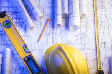 Mimarlık ve inşaat kavramı. Rulo planları, libela ve kask oluşturucu. 