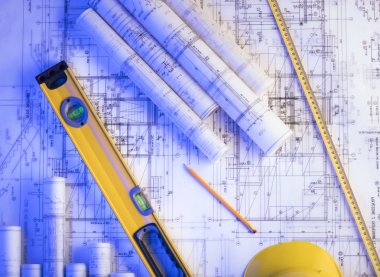 Mimarlık ve inşaat kavramı. Rulo planları, libela ve kask oluşturucu. 