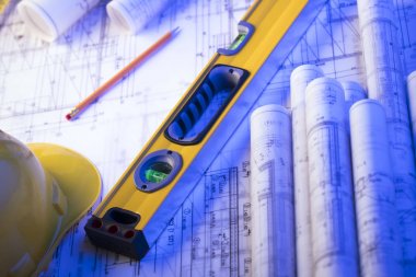 Mimarlık ve inşaat kavramı. Rulo planları, libela ve kask oluşturucu. 