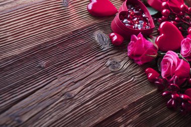 Sevgiliye arka plan. Kalpler, gül, hediyeler ve rustik ahşap masa üzerinde romantik süslemeleri. Tipografi için yer