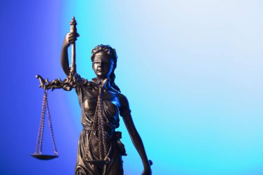 Hukuk ve adalet kavramı. Themis heykeli mavi zemin üzerine.