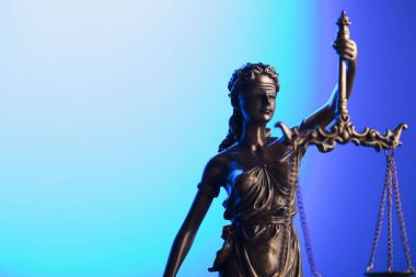 Hukuk ve adalet kavramı. Themis heykeli mavi zemin üzerine.