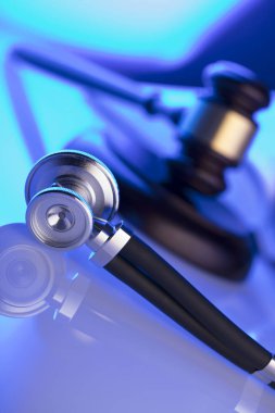 Tıp hukuku kavramı. Tokmak, stetoskop, mavi ışık. Yer fort metin.