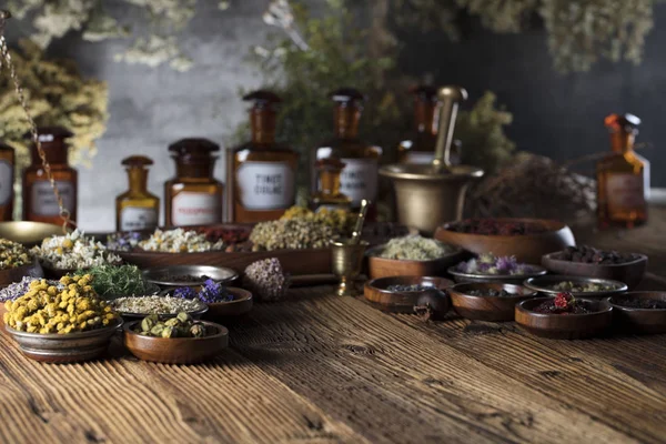 自然医学背景 黄铜砂浆 质朴的桌子 各式干草药在碗里 — 图库照片