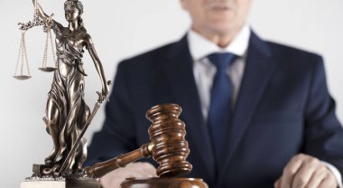  Yasal danışman. Beyaz masa ve arka plan üzerinde çekiç ve Themis heykeli.