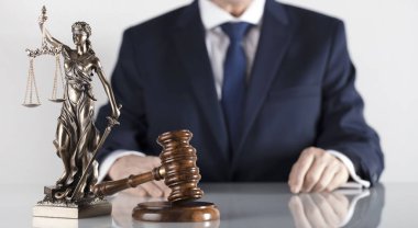  Yasal danışman. Beyaz masa ve arka plan üzerinde çekiç ve Themis heykeli.