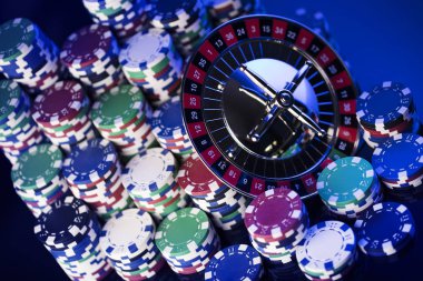 Casino kavramı. Casino rulet, poker fişleri yüksek kontrast görüntü. Mavi ışık ve metin için yer.
