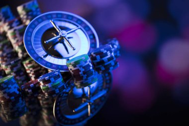 Casino kavramı. Casino rulet, poker fişleri yüksek kontrast görüntü. Mavi ışık ve metin için yer.