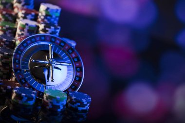 Casino kavramı. Casino rulet, poker fişleri yüksek kontrast görüntü. Mavi ışık ve metin için yer.