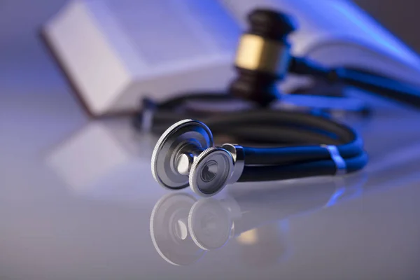 Medical law concept. Gavel, stethoscope, blue light. Place fort text.