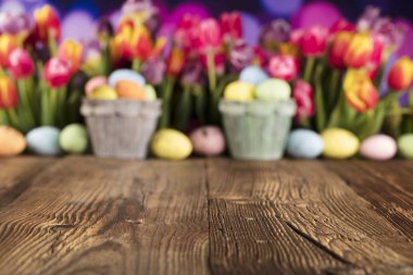 Paskalya Tema. Paskalya yumurtaları. Renkli Lale. Rustik ahşap masa. Odak sığ derinliği. Bokeh arka plan. Typhography için yer.