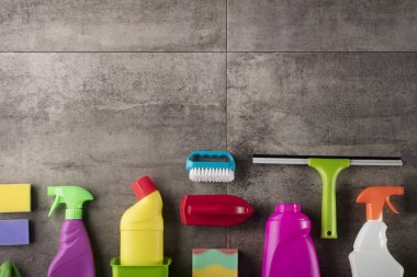 Bahar Temizlik kavramı. Temizleme ürünleri, gri döşeme üzerinde renkli. Tipografi için yer.
