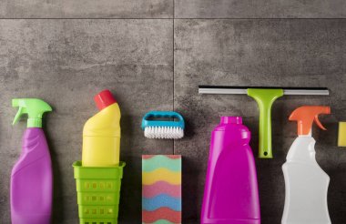 Bahar Temizlik kavramı. Temizleme ürünleri, gri döşeme üzerinde renkli. Tipografi için yer.