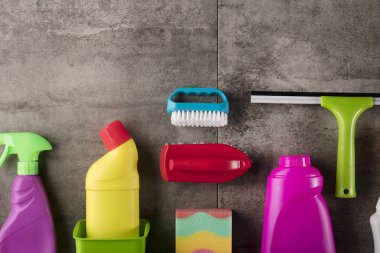 Bahar Temizlik kavramı. Temizleme ürünleri, gri döşeme üzerinde renkli. Tipografi için yer.