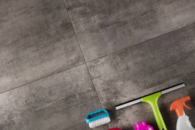 Bahar Temizlik kavramı. Temizleme ürünleri, gri döşeme üzerinde renkli. Tipografi için yer.