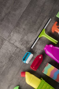Bahar Temizlik kavramı. Temizleme ürünleri, gri döşeme üzerinde renkli. Tipografi için yer.