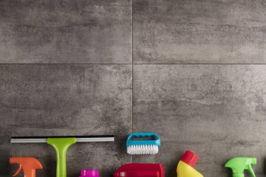 Bahar Temizlik kavramı. Temizleme ürünleri, gri döşeme üzerinde renkli. Tipografi için yer.