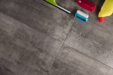 Bahar Temizlik kavramı. Temizleme ürünleri, gri döşeme üzerinde renkli. Tipografi için yer.