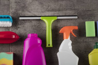 Bahar Temizlik kavramı. Temizleme ürünleri, gri döşeme üzerinde renkli. Tipografi için yer.