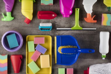 Bahar Temizlik kavramı. Temizleme ürünleri, gri döşeme üzerinde renkli. Tipografi için yer.