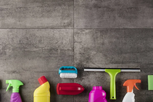 Bahar Temizlik kavramı. Temizleme ürünleri, gri döşeme üzerinde renkli. Tipografi için yer.