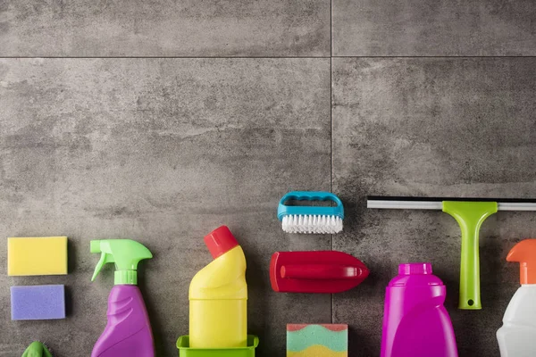 Bahar Temizlik kavramı. Temizleme ürünleri, gri döşeme üzerinde renkli. Tipografi için yer.