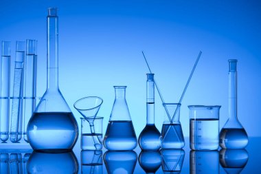 Bilim laboratuarı. Laboratuar kapkacakları, test tüpleri. Araştırma ve geliştirme. Mavi arka plan.