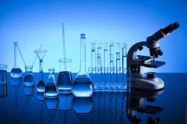 Bilim laboratuarı. Laboratuar kapkacakları, mikroskop, test tüpleri. Araştırma ve geliştirme. Mavi arka plan.