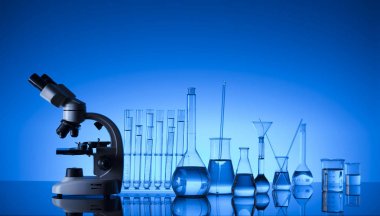 Bilim laboratuarı. Laboratuar kapkacakları, mikroskop, test tüpleri. Araştırma ve geliştirme. Mavi arka plan.