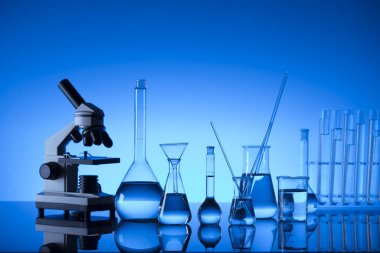 Bilim laboratuarı. Laboratuar kapkacakları, mikroskop, test tüpleri. Araştırma ve geliştirme. Mavi arka plan.