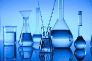 Bilim laboratuarı. Laboratuar kapkacakları, test tüpleri. Araştırma ve geliştirme. Mavi arka plan.