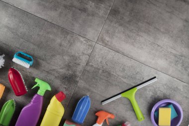 Bahar Temizlik kavramı. Temizleme ürünleri, gri döşeme üzerinde renkli. Tipografi için yer.