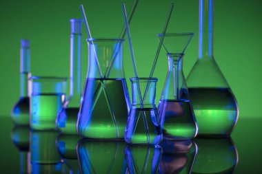 Kimyasal laboratuvar kavramı. Sıvı ile denemeler yapın. Yeşil arka plan. Logo için yer.