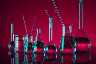 Kimyasal laboratuvar kavramı. Sıvı ile denemeler yapın. Kırmızı arka plan. Logo için yer.