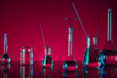 Kimyasal laboratuvar kavramı. Sıvı ile denemeler yapın. Kırmızı arka plan. Logo için yer.