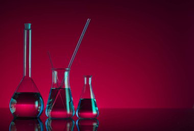 Kimyasal laboratuvar kavramı. Sıvı ile denemeler yapın. Kırmızı arka plan. Logo için yer.